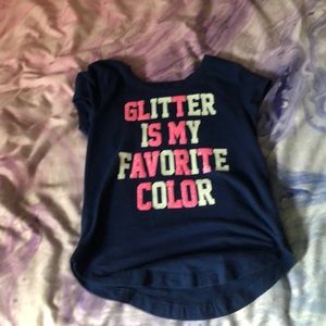 A navy blue t shirt that has pink sparkly words